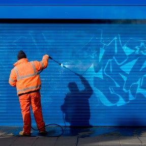 Man Pressure Washing Graffiti