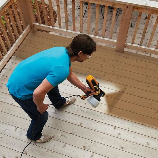 Man Using Spray Gun On Deck